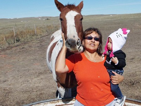 Irene Red Cloud and horse and young child